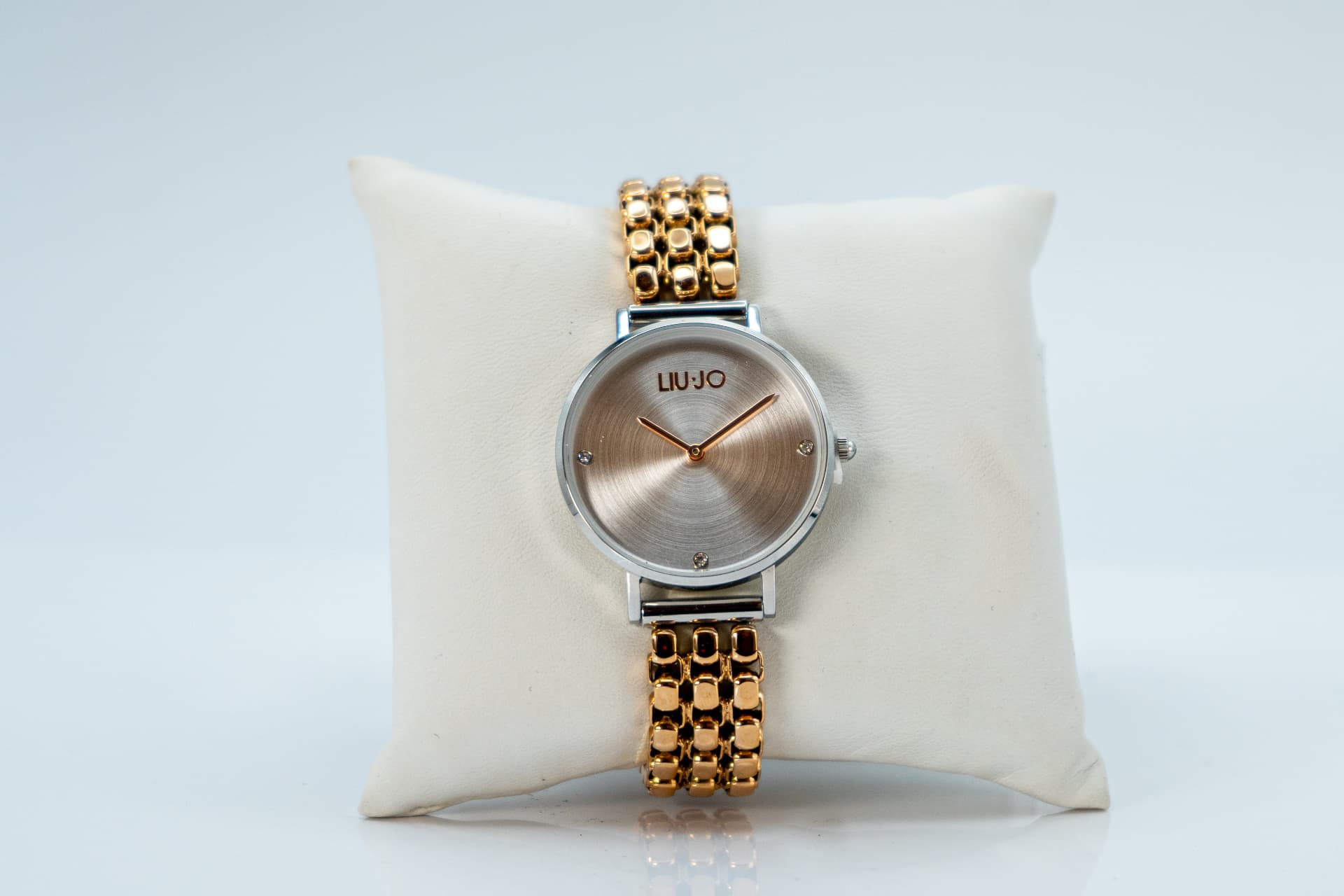 Orologio da donna Liu Jo con quadrante rosato e bracciale dorato, appoggiato su un cuscinetto bianco