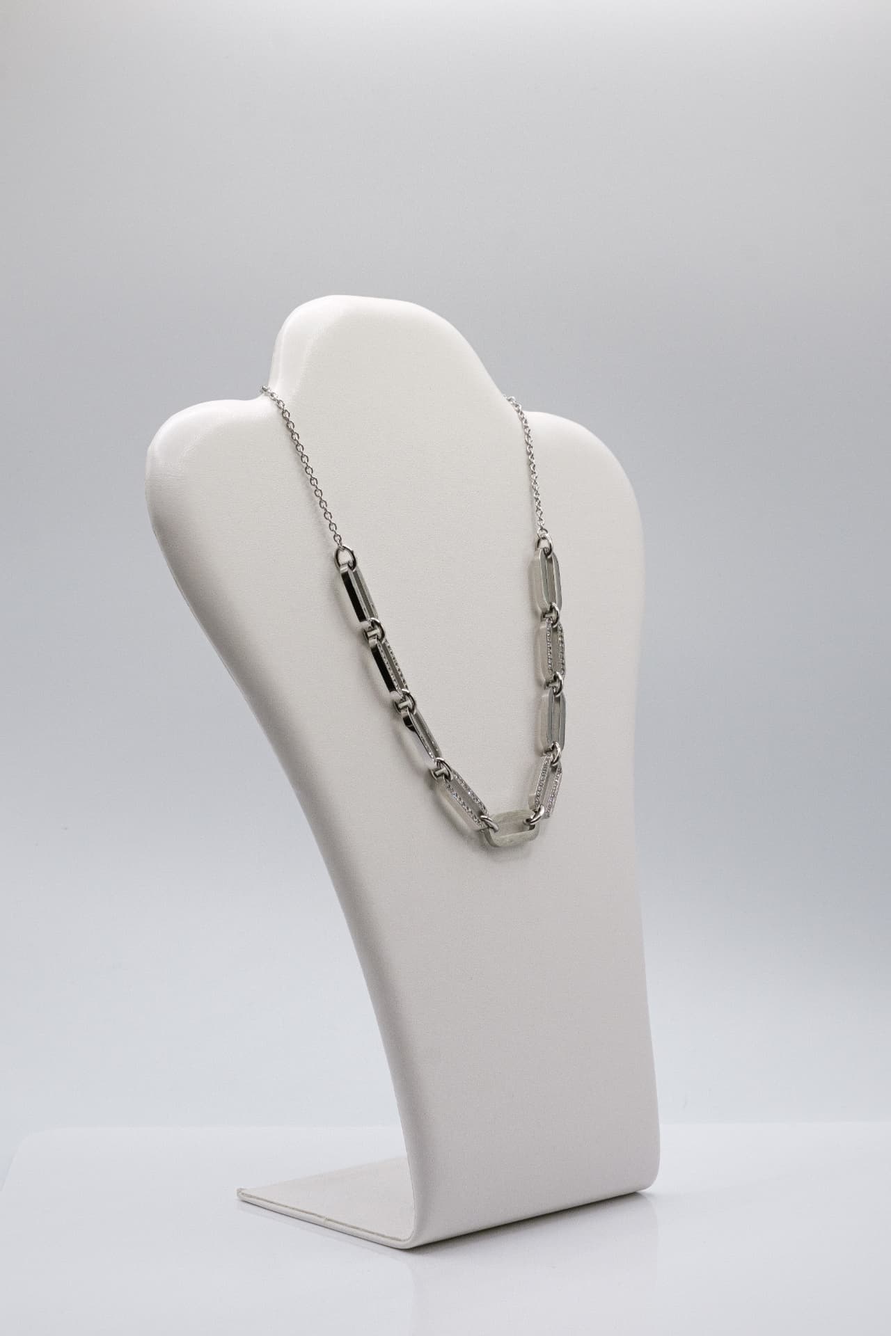 Collana in acciaio con maglie rettangolari e cristalli, su espositore